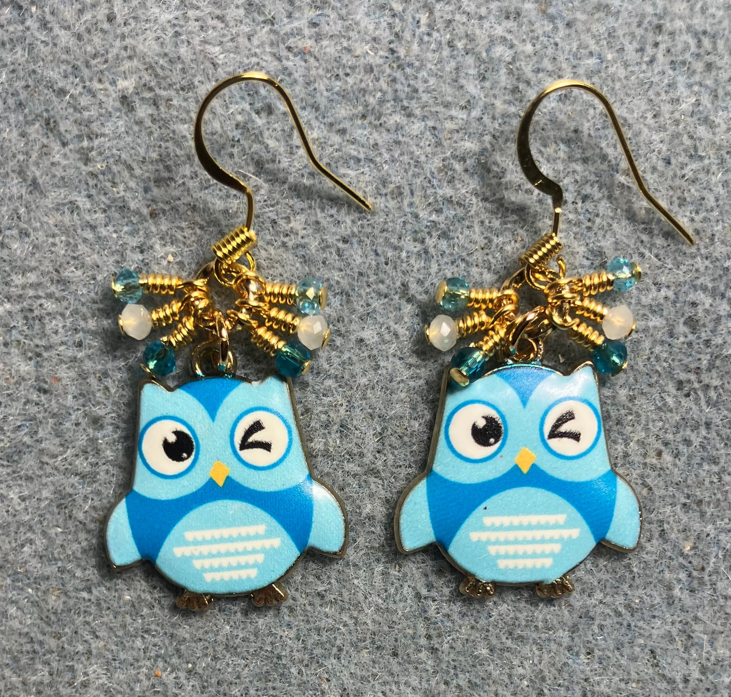 Turquoise and white enamel owl charm earrings adorned with tiny dangling dark turquoise, light turquoise, and white Chinese crystal beads.