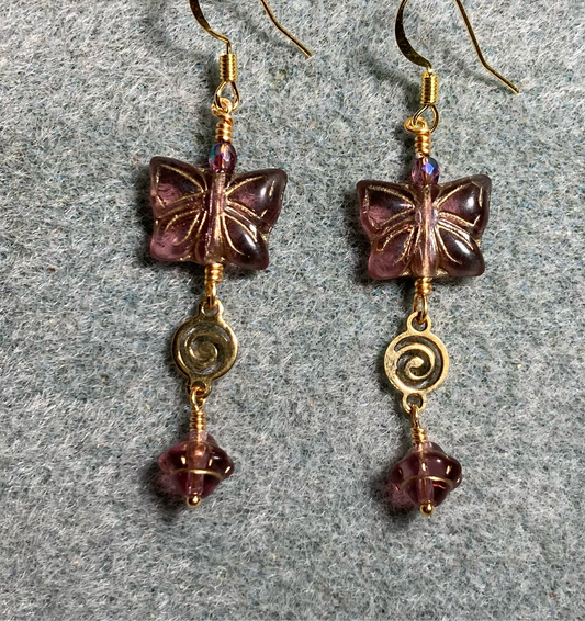 Purple Czech glass butterfly bead earrings adorned with gold swirly connectors and purple Czech glass Saturn beads.