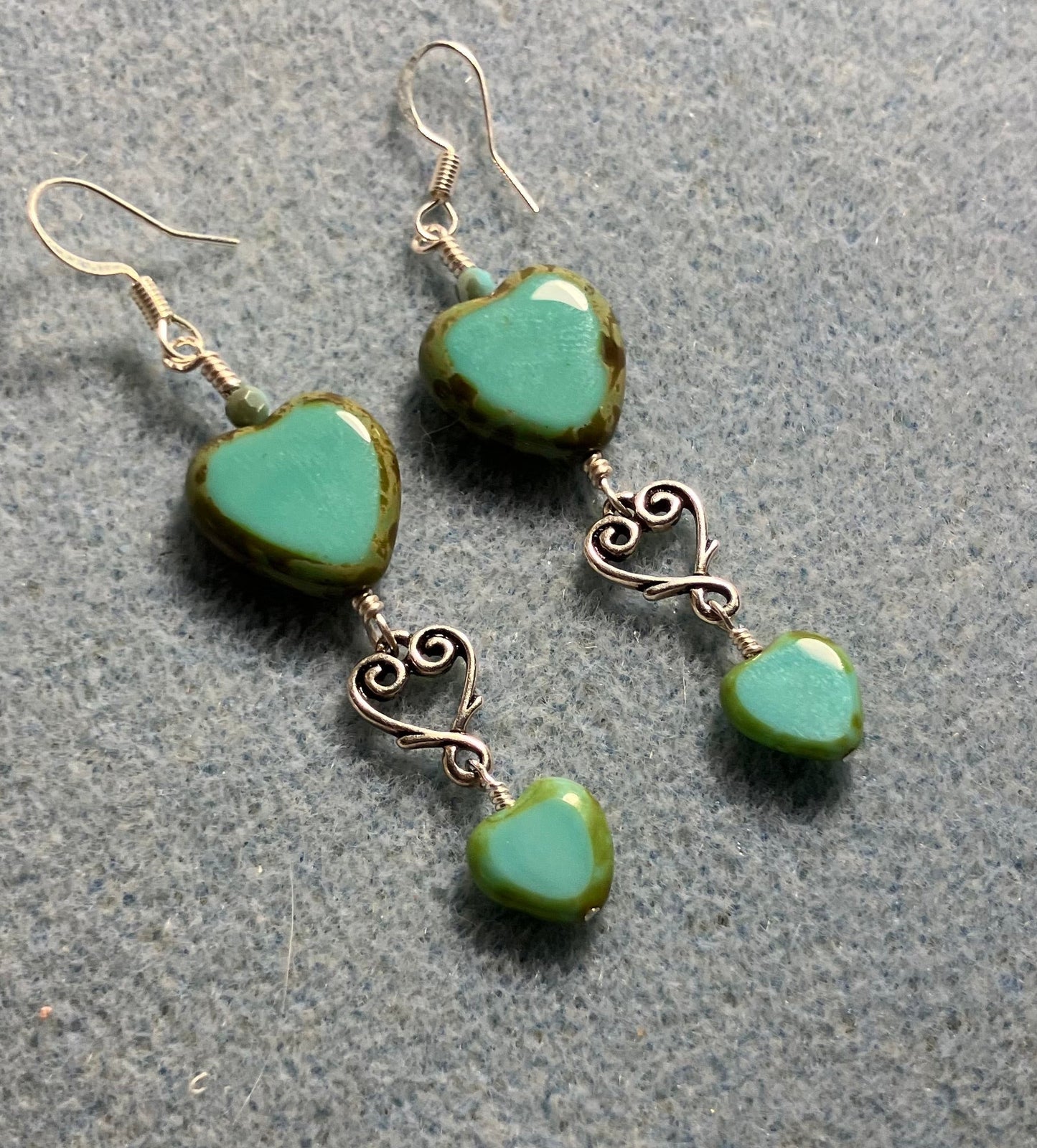 Large and small matching opaque turquoise Czech glass heart bead earrings joined by silver Tierracast heart connectors.