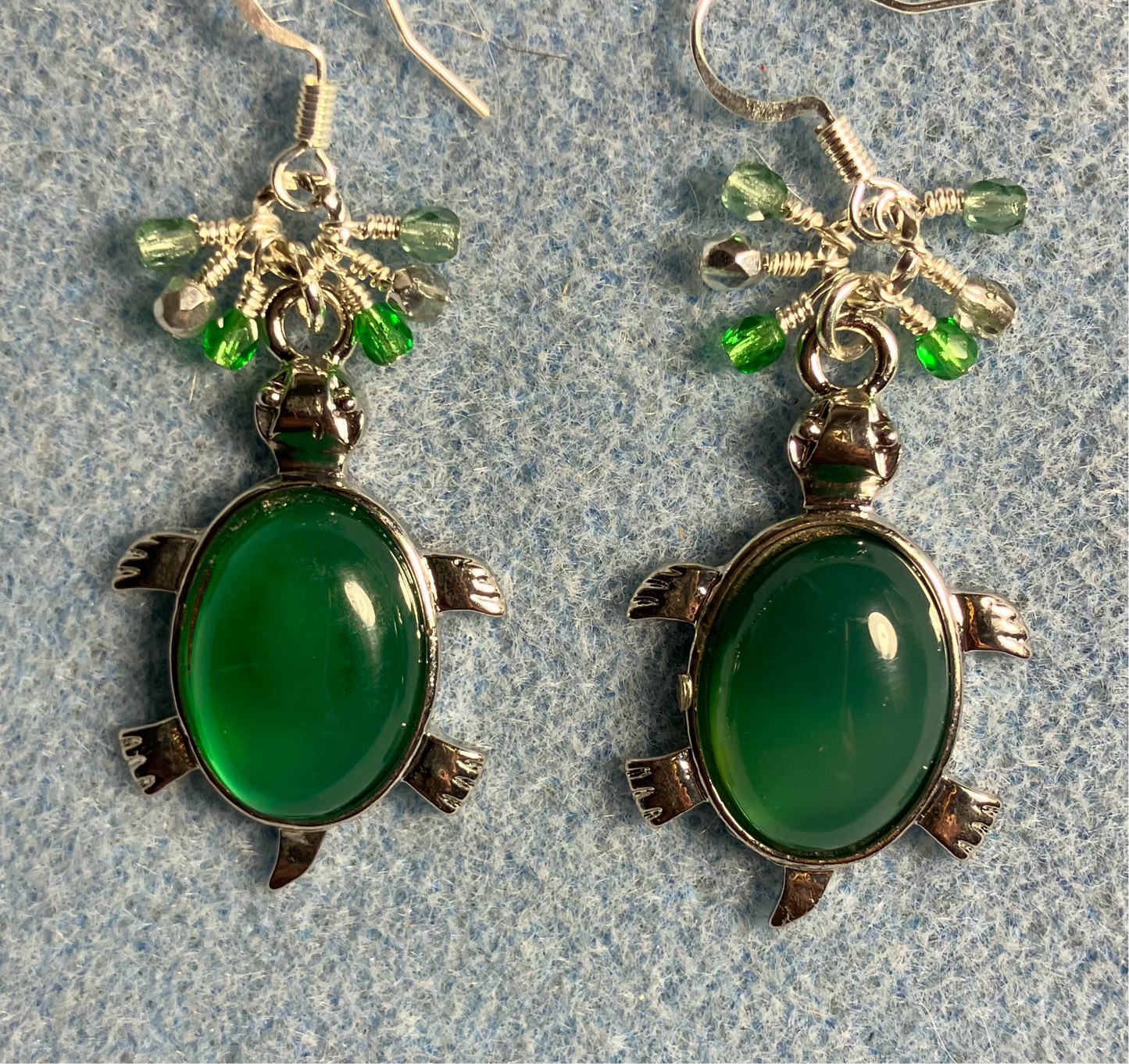 Large silver and green agate gemstone turtle charm earrings adorned with small dangling green and silver Czech glass beads.