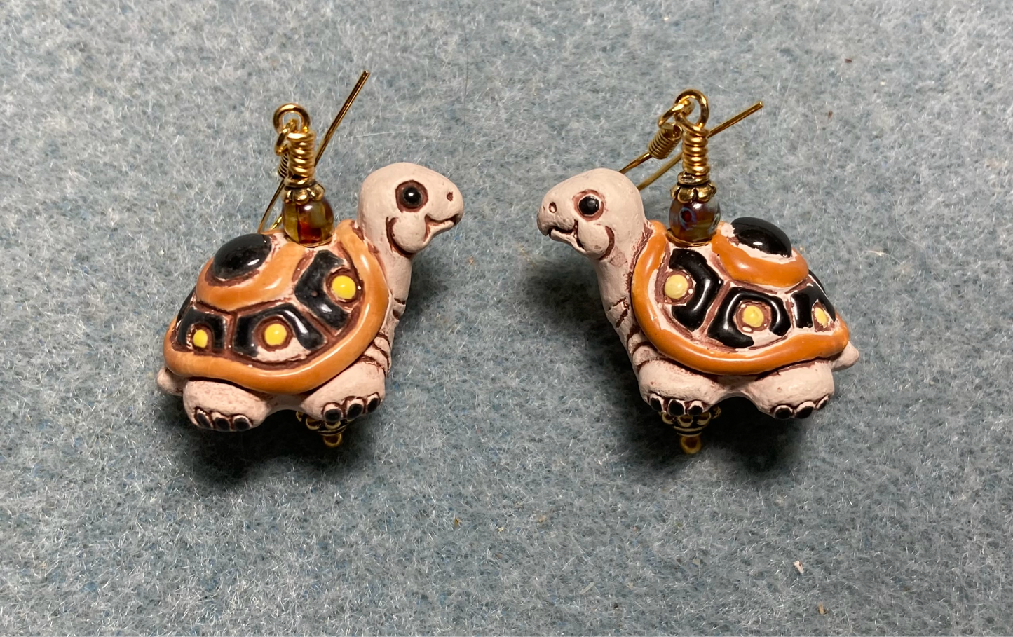 Large brown and orange ceramic turtle bead earrings adorned with brown Czech glass beads.