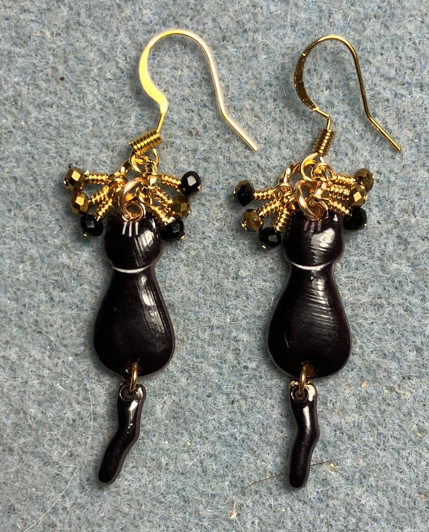 Black and gold enamel cat charm earrings adorned with tiny dangling black and gold Chinese crystal beads.