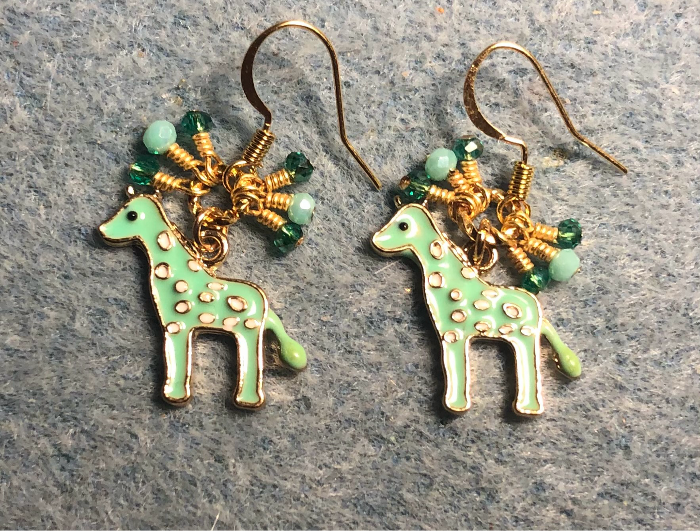 Light green enamel spotted giraffe charm earrings adorned with tiny dangling aqua and green Chinese crystal beads.