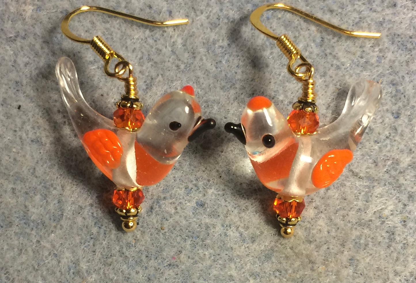 Clear and orange lamp work songbird bead earrings adorned with orange Chinese crystal beads.