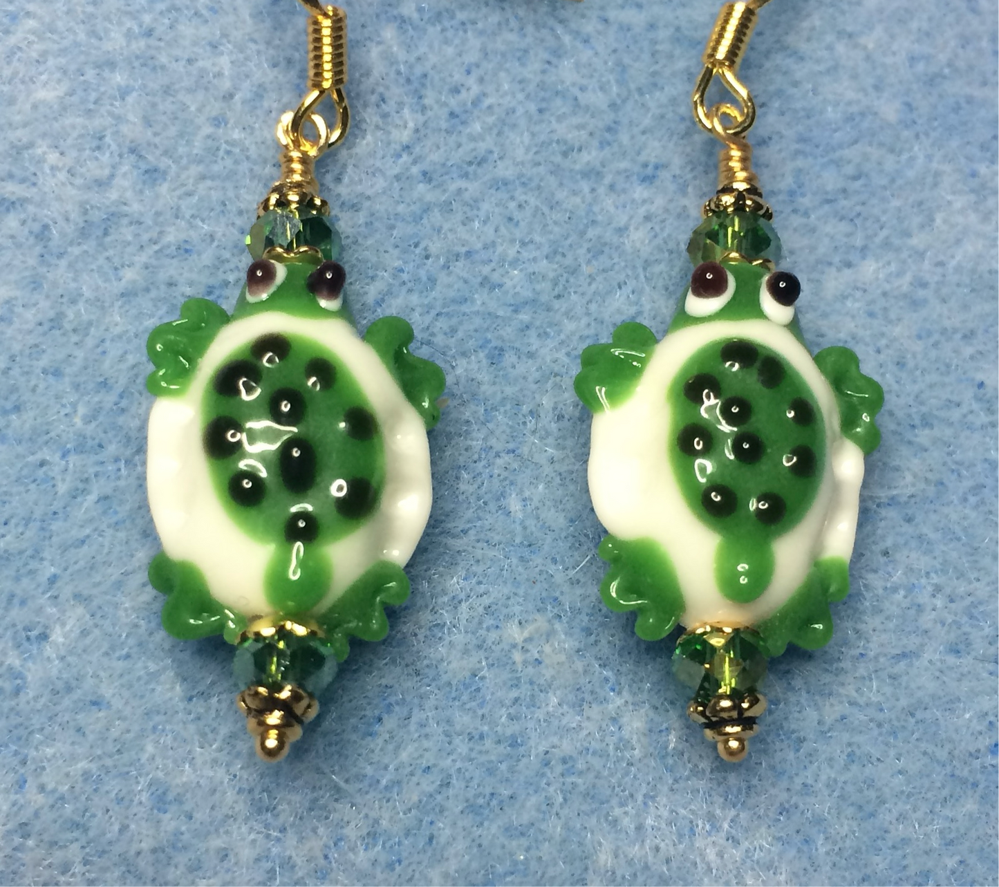 Green and white lamp work spotted turtle bead earrings adorned with green Chinese crystal beads.