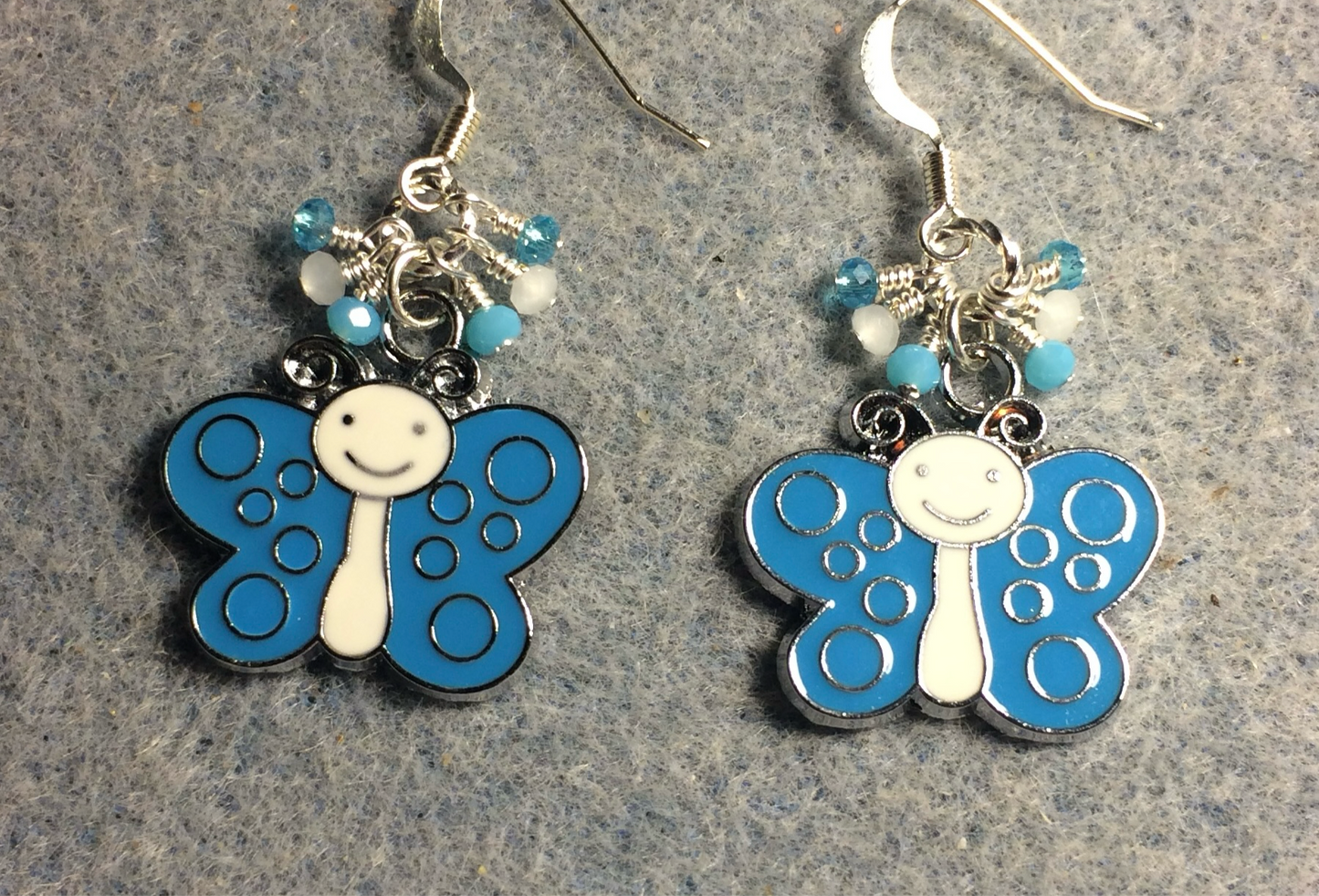 Silly turquoise and white enamel butterfly charm earrings adorned with tiny dangling turquoise and white Chinese crystal beads.