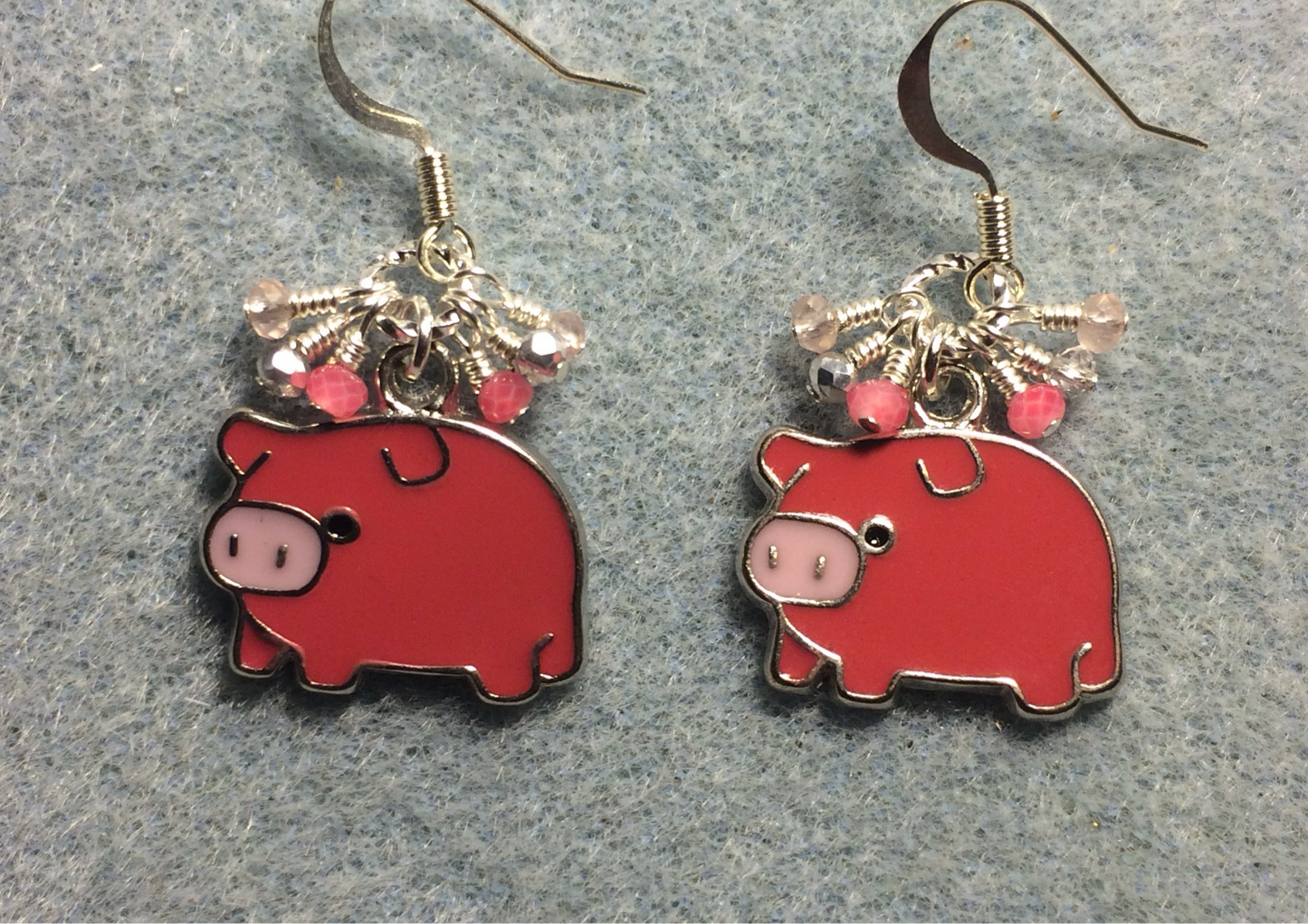 Dark pink and light pink enamel pig charm earrings adorned with tiny dangling dark pink, light pink, and silver Chinese crystal beads.