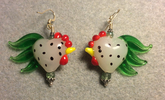 Milky white and green with black spots heart shaped lamp work rooster bead earrings adorned with green Czech glass beads.