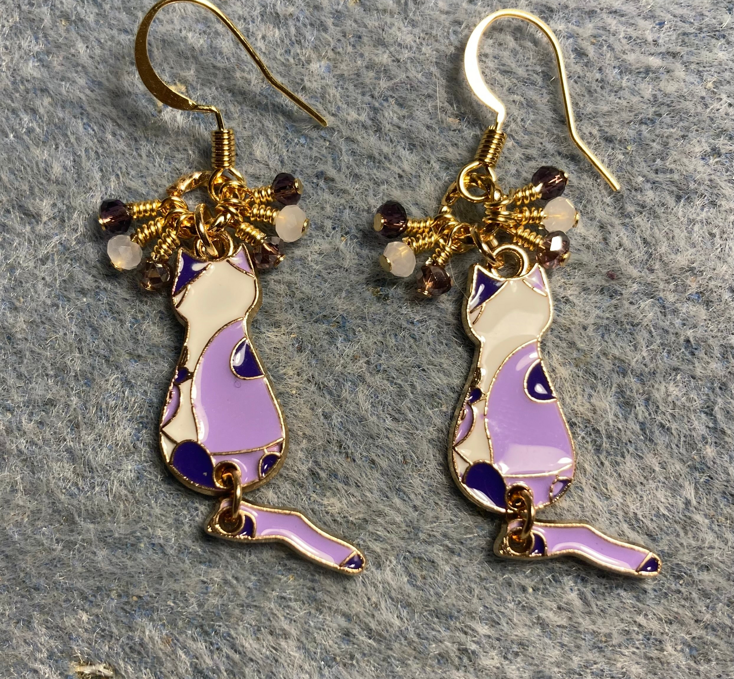Violet, dark purple, and white enamel calico cat charm earrings adorned with tiny dangling violet, dark purple, and white Chinese crystal beads.