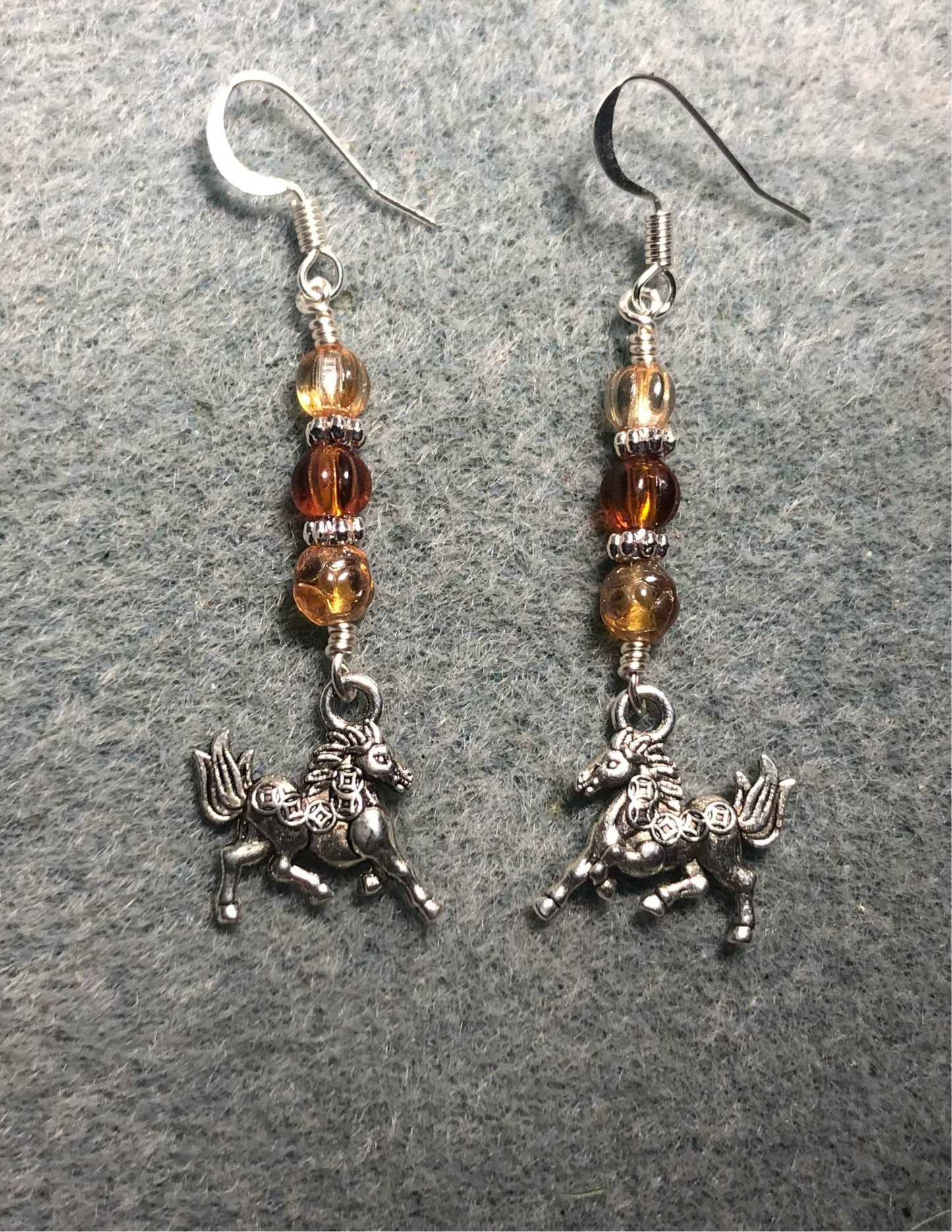 Small silver horse charm earrings adorned with small amber Czech glass beads.