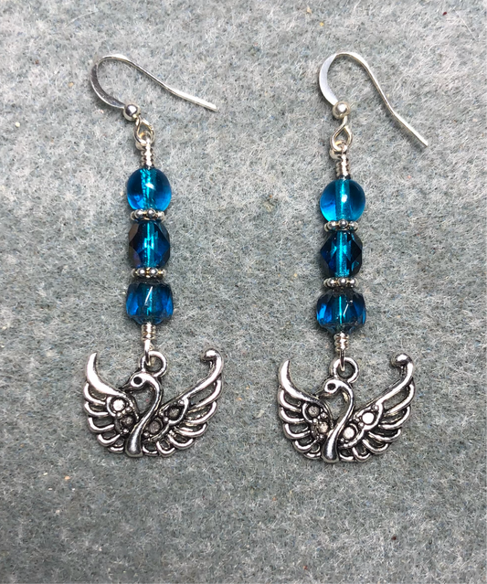 Silver swan charm earrings adorned with dark turquoise Czech glass beads.