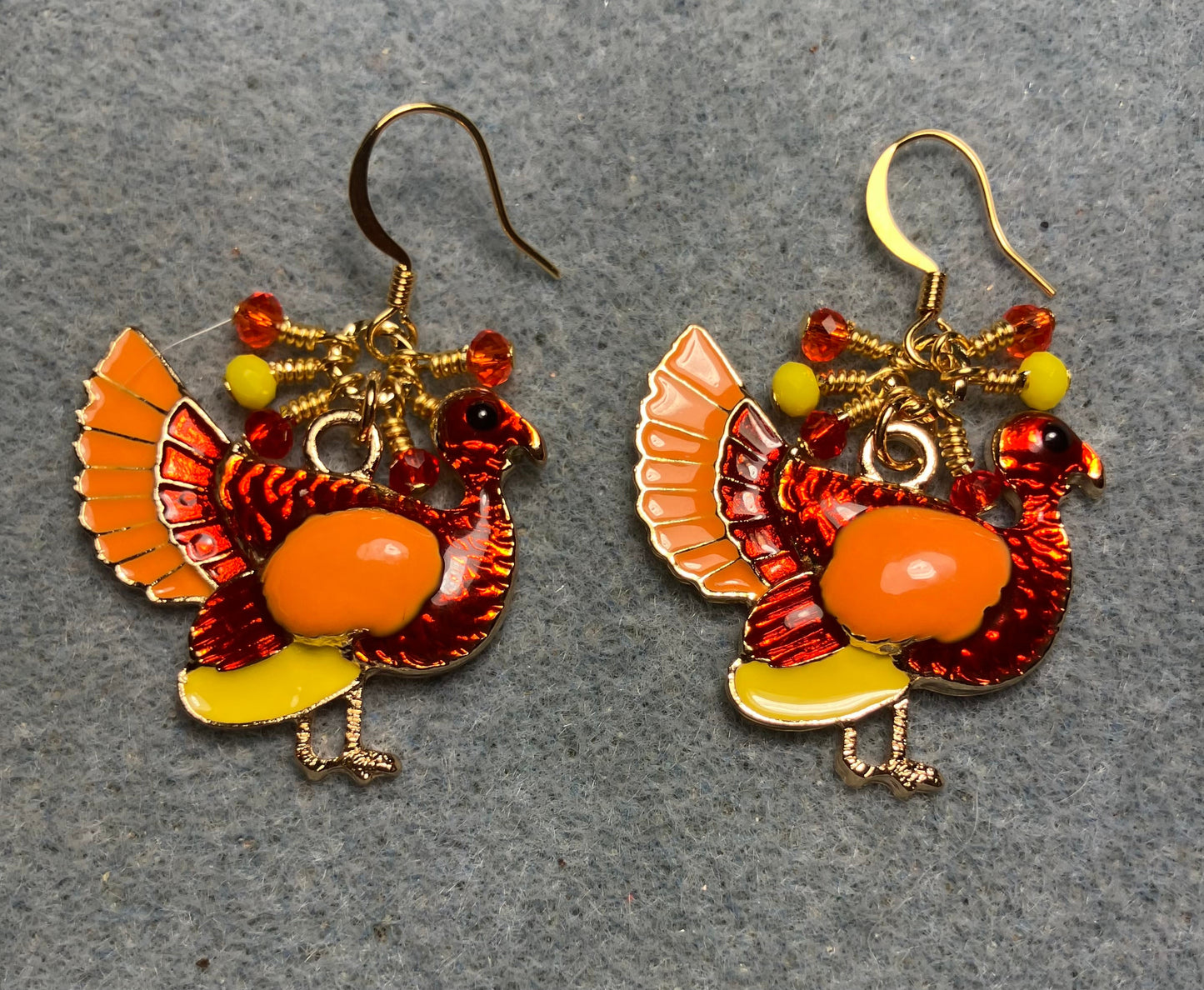 Red, orange, and yellow enamel turkey charm earrings adorned with small dangling red, orange, and yellow Chinese crystal beads.