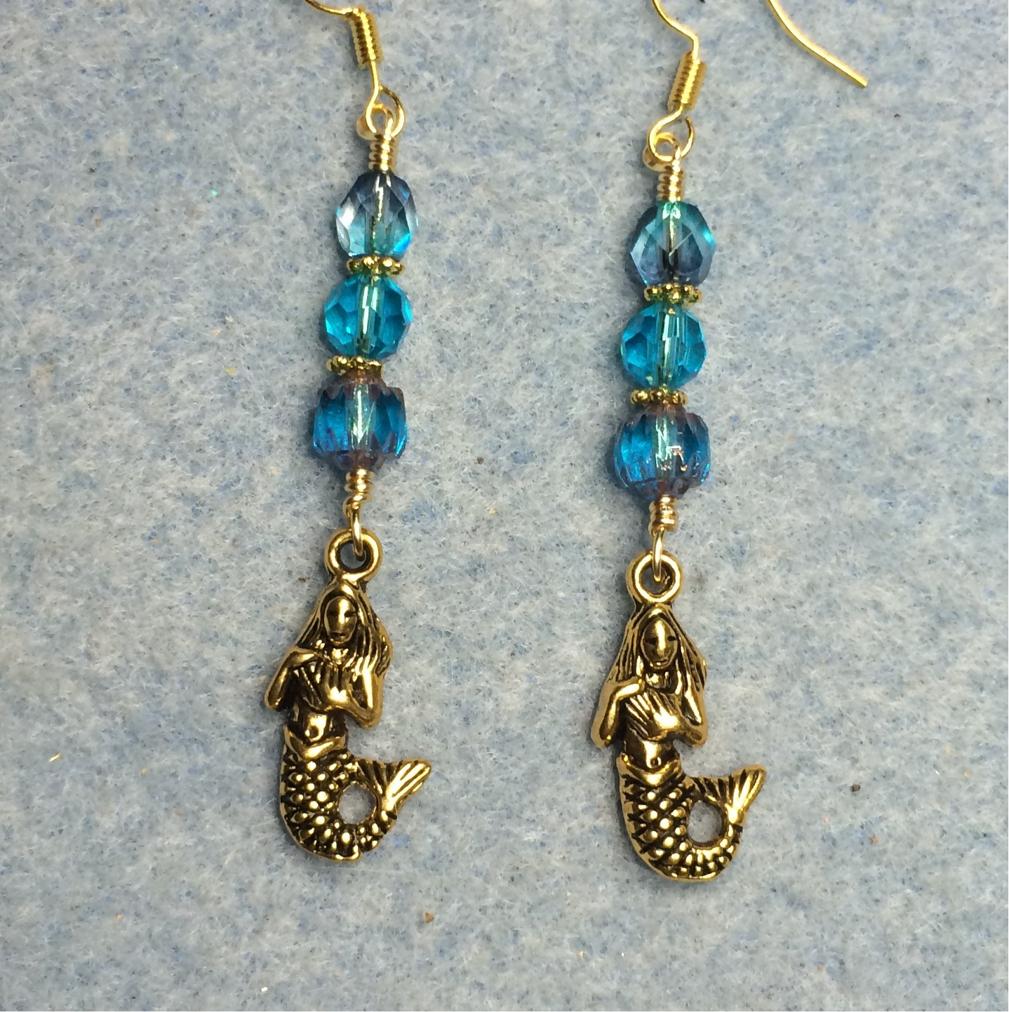 Gold mermaid charm earrings adorned with turquoise Czech glass beads