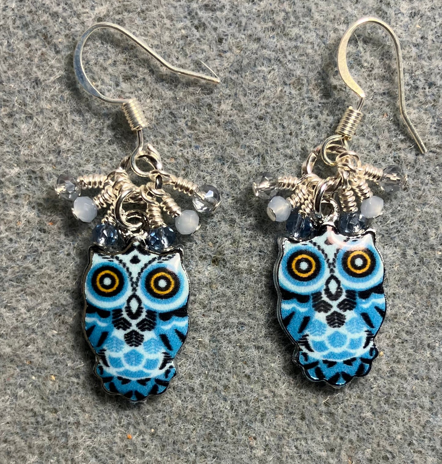 Blue, black, and silver enamel owl charm earrings adorned with tiny dangling dark blue and light blue Chinese crystal beads.