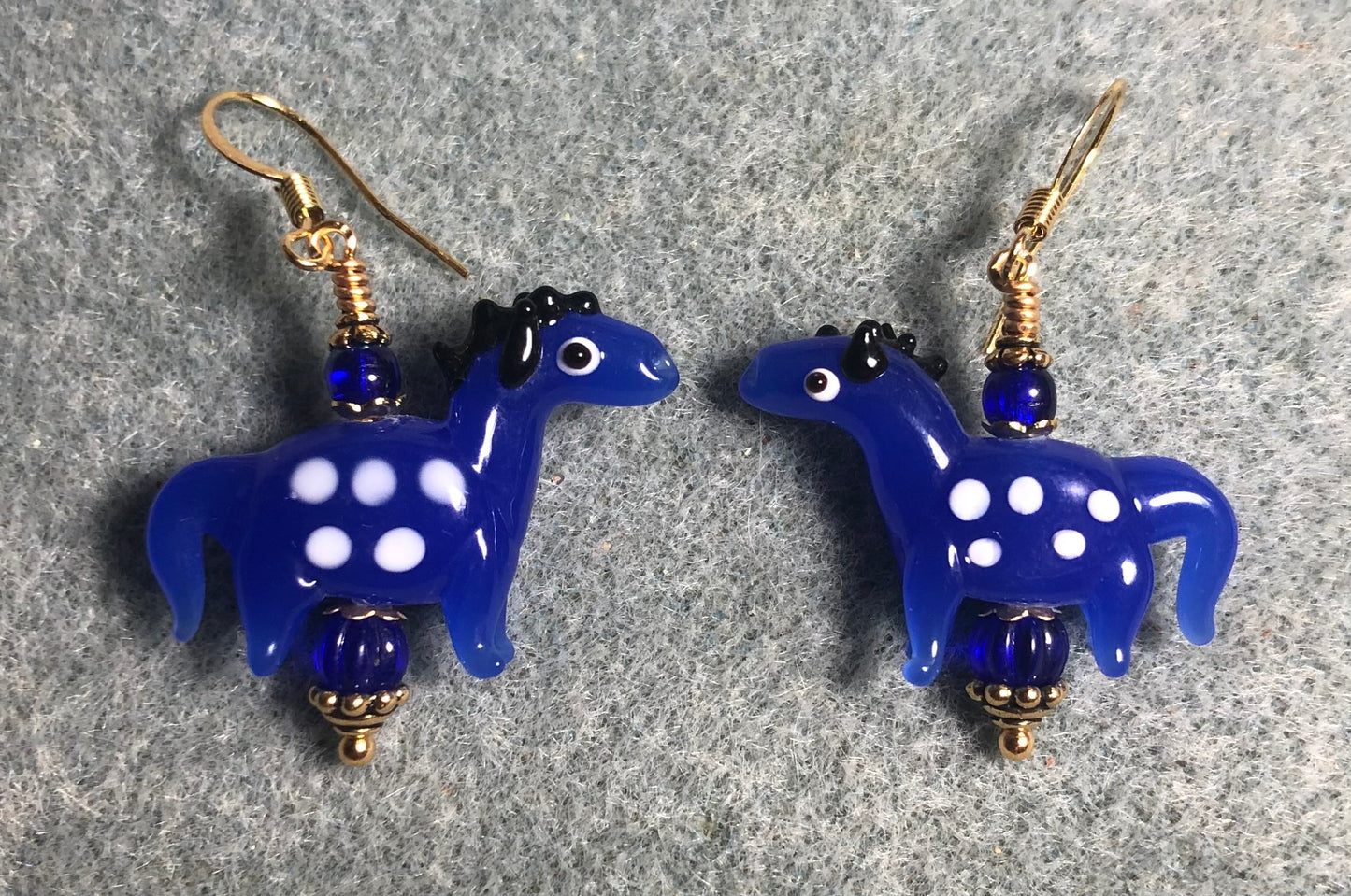 Opaque dark blue lamp work spotted horse bead earrings adorned with dark blue Czech glass beads.