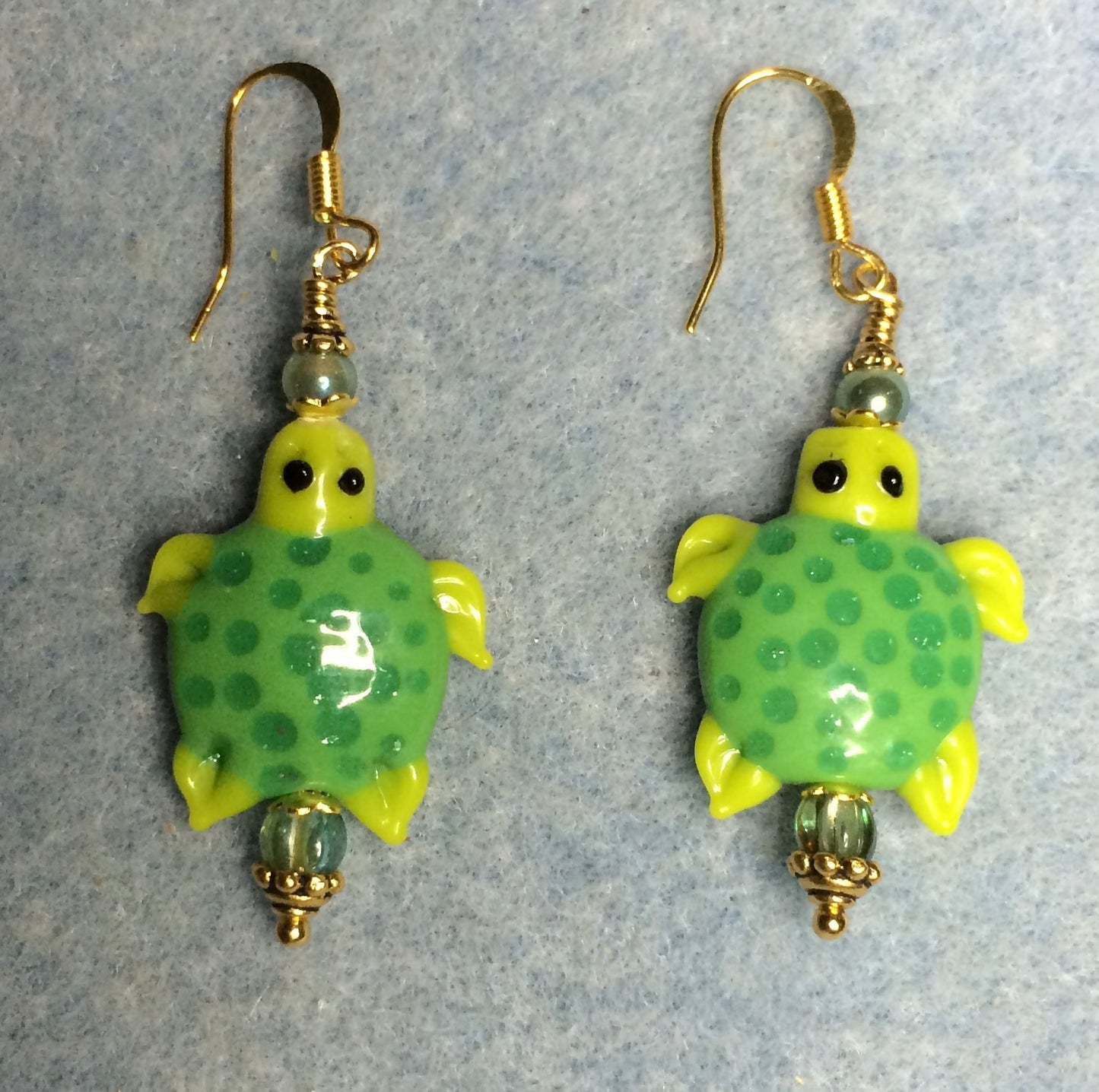 Green lamp work spotted turtle bead earrings adorned with green Czech glass beads.