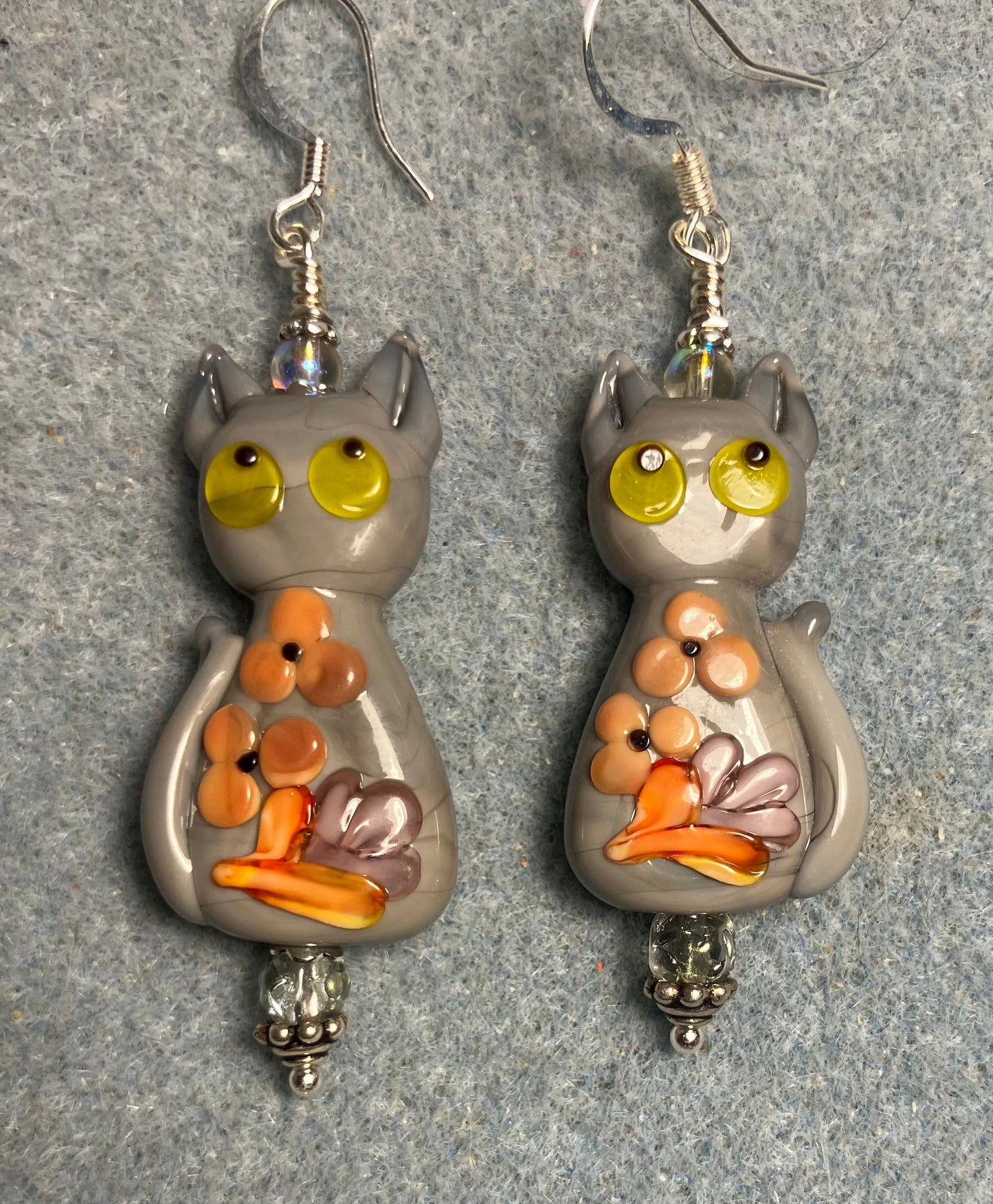 Large gray, orange, and yellow lamp work cat bead earrings adorned with gray Czech glass beads.