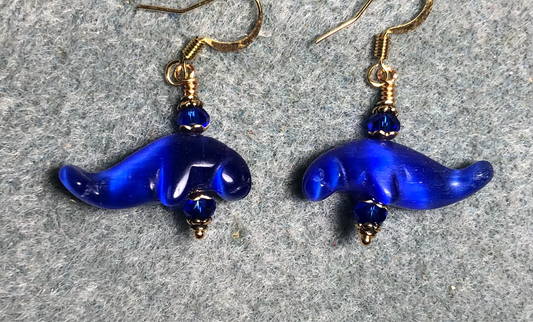Dark blue fiber optic (cat’s eye) manatee bead earrings adorned with dark blue Chinese crystal beads.