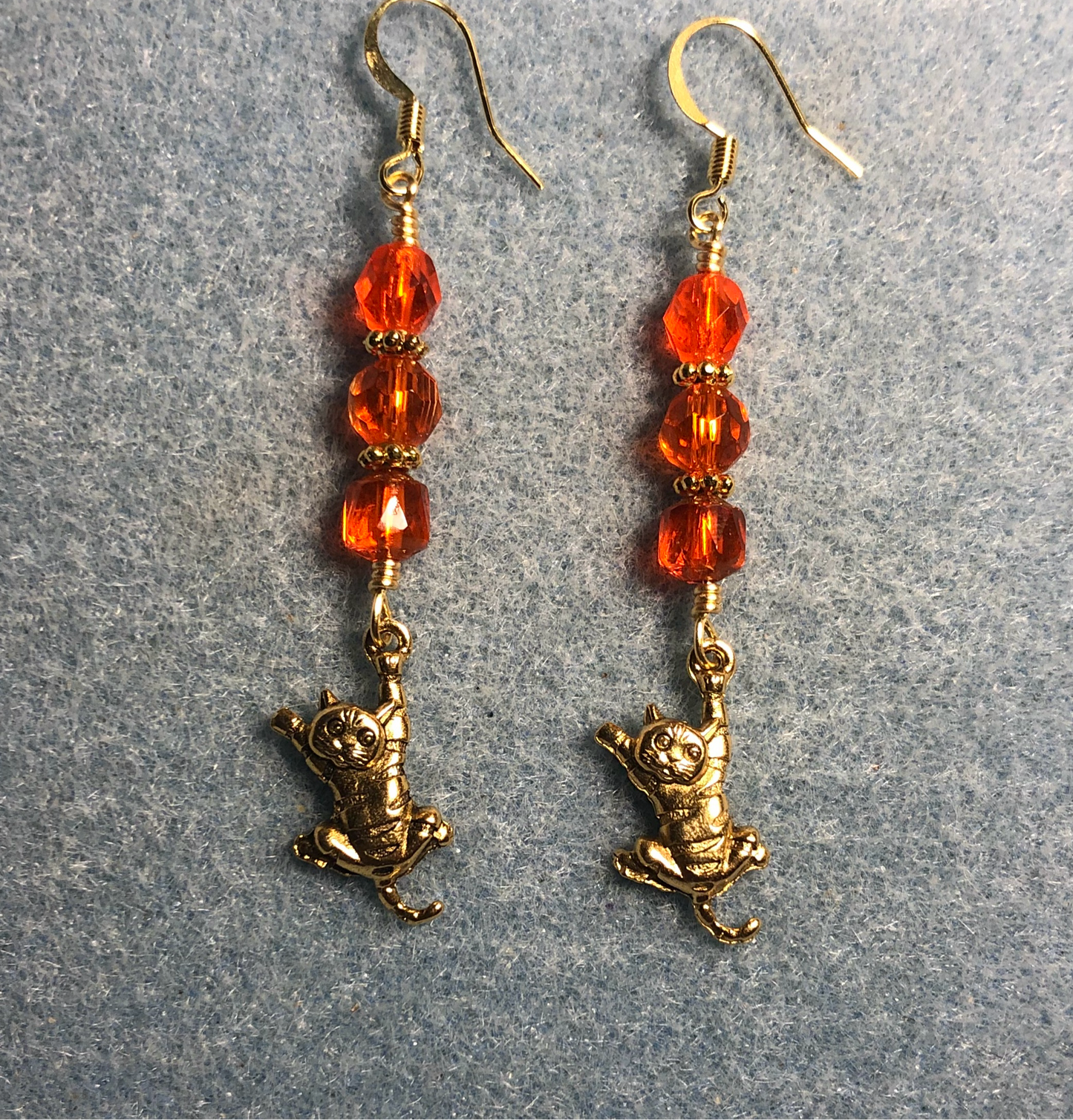 Gold tabby cat charm earrings adorned with orange Czech glass beads