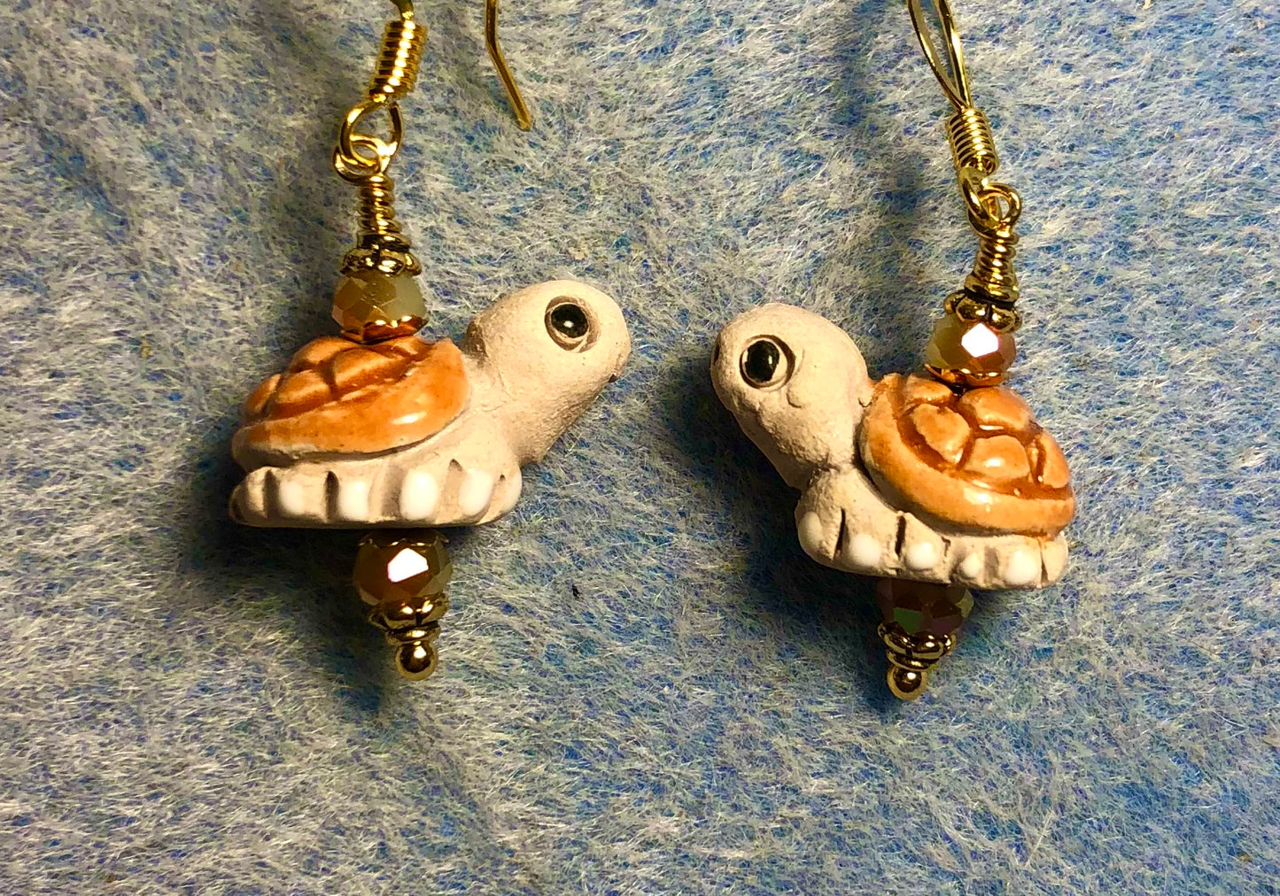 Small light brown and tan ceramic turtle bead earrings adorned with light brown Chinese crystal beads.