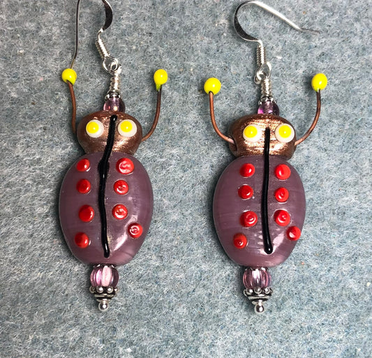 Purple, red, and yellow lamp work beetle bead earrings adorned with purple Czech glass beads.