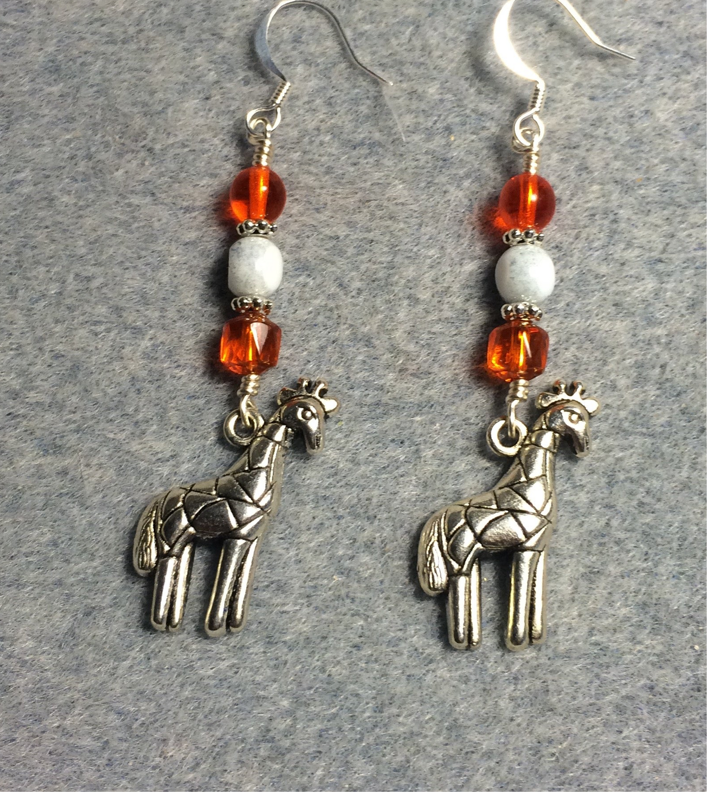 Silver giraffe charm earrings adorned with orange and white Czech glass beads