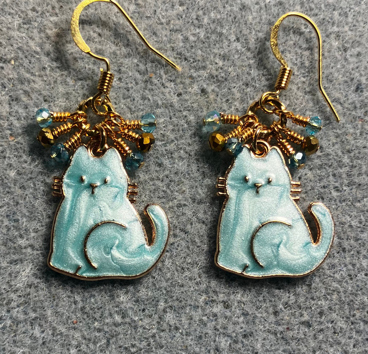 Turquoise and gold enamel cat charm earrings adorned with tiny dangling turquoise and gold Chinese crystal beads.