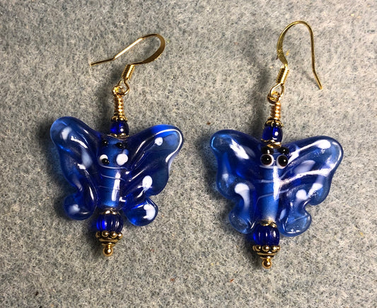 Bright blue lamp work butterfly bead earrings adorned with dark blue Czech glass beads.