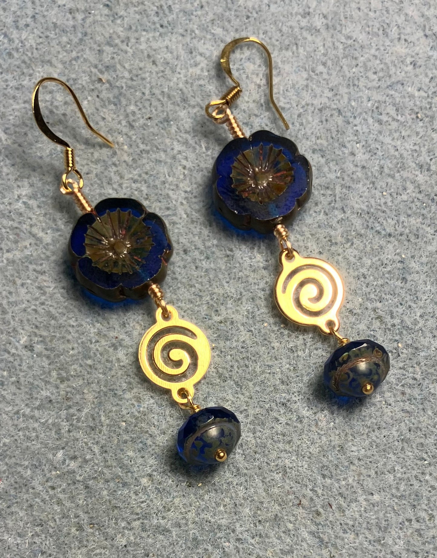 Cobalt blue Czech glass pansy bead earrings adorned with gold swirly connectors and cobalt blue Czech glass Saturn beads.