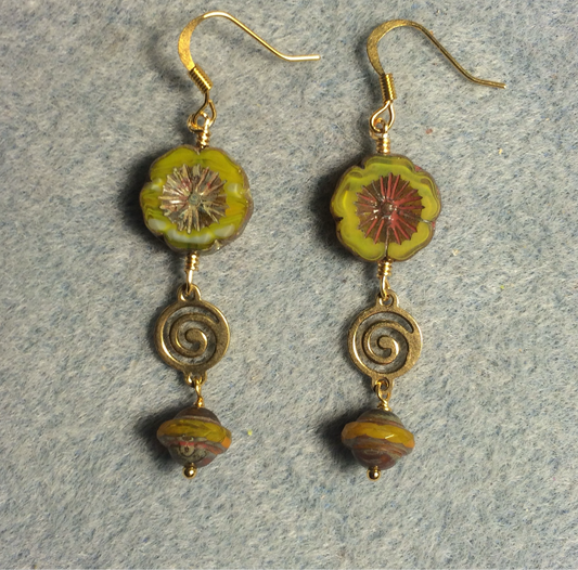 Opaque yellow green Czech glass pansy bead earrings adorned with gold swirly connectors and yellow green Czech glass Saturn beads.