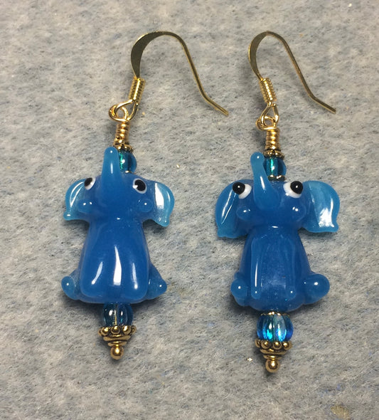 Opaque turquoise lamp work sitting elephant bead earrings adorned with turquoise Czech glass beads.