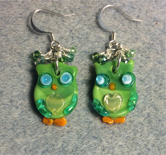 Flat green, blue, and orange lamp work owl charm earrings adorned with tiny dangling green and blue Chinese crystal beads.