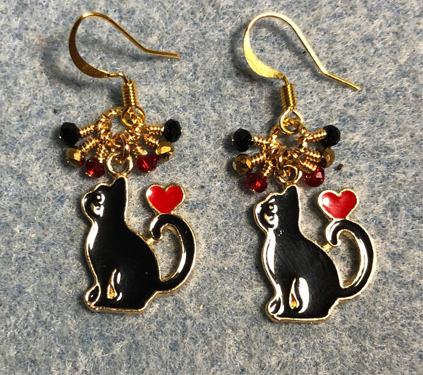 Black and red enamel cat charm earrings adorned with tiny dangling black, gold, and red Chinese crystal beads.