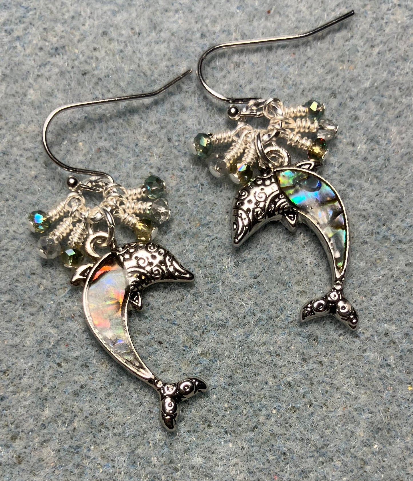 Silver and abalone dolphin charm earrings adorned with tiny dangling green and silver Chinese crystal beads.