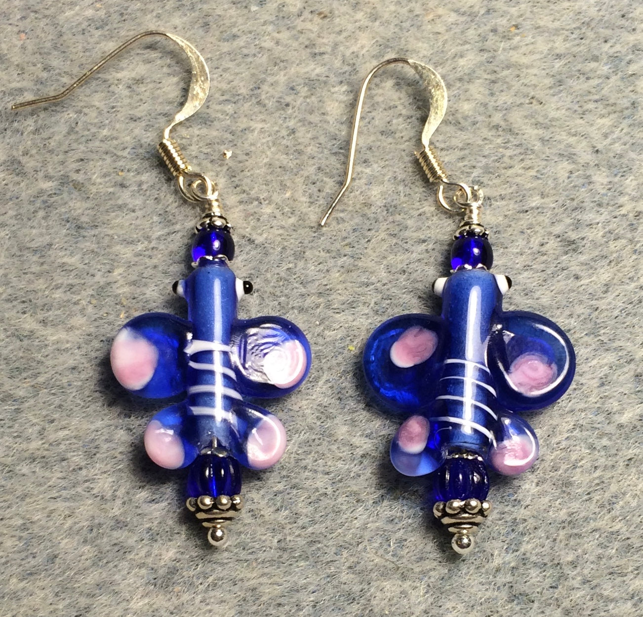 Dark blue and pink lamp work butterfly bead earrings adorned with dark blue Czech glass beads.