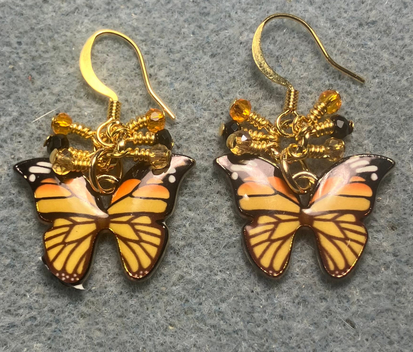 Orange and black enamel butterfly charm earrings adorned with tiny dangling orange, black, and amber Chinese crystal beads.