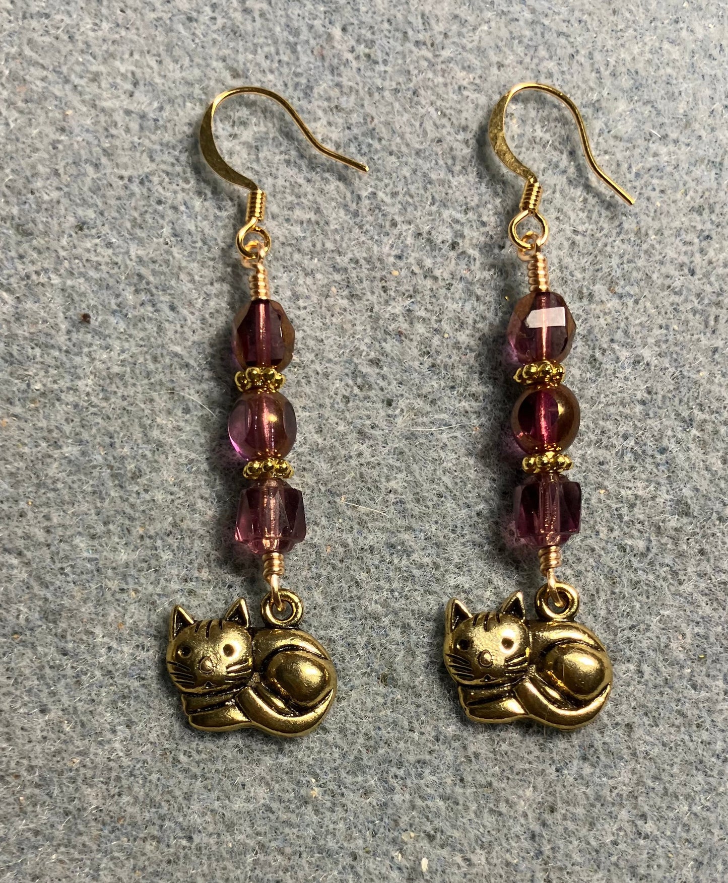 Gold sleeping cat charm earrings adorned with violet Czech glass beads