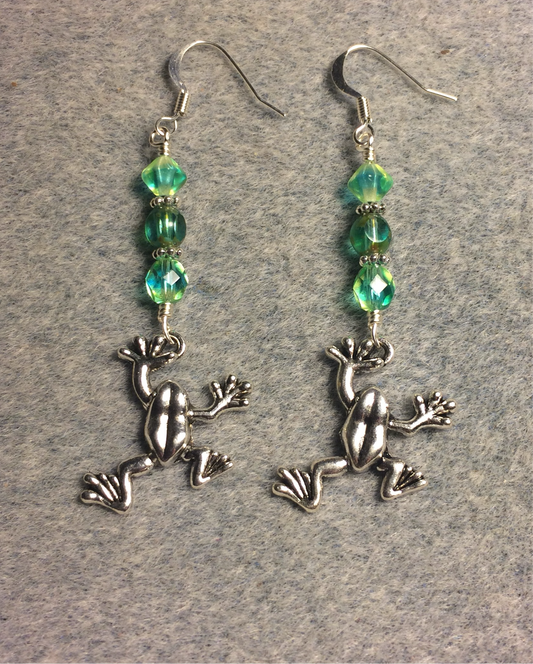 Silver jumping frog charm earrings adorned with light yellowish green Czech glass beads.