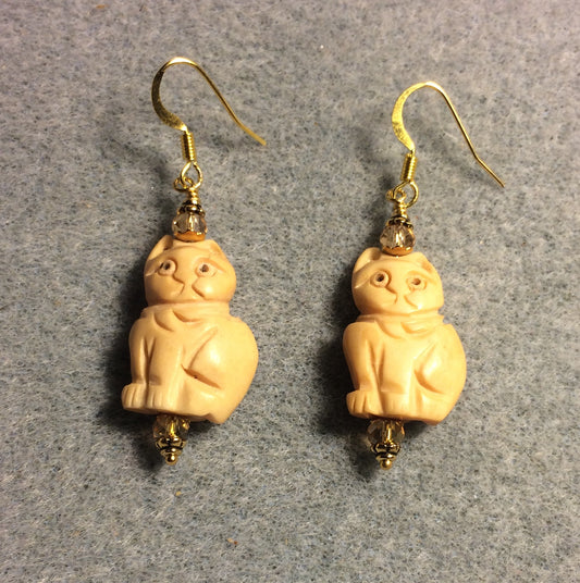 Beige intricately carved cat bead earrings adorned with topaz Chinese crystal beads.