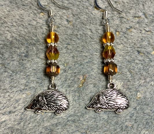 Silver hedgehog charm earrings adorned with amber Czech glass beads