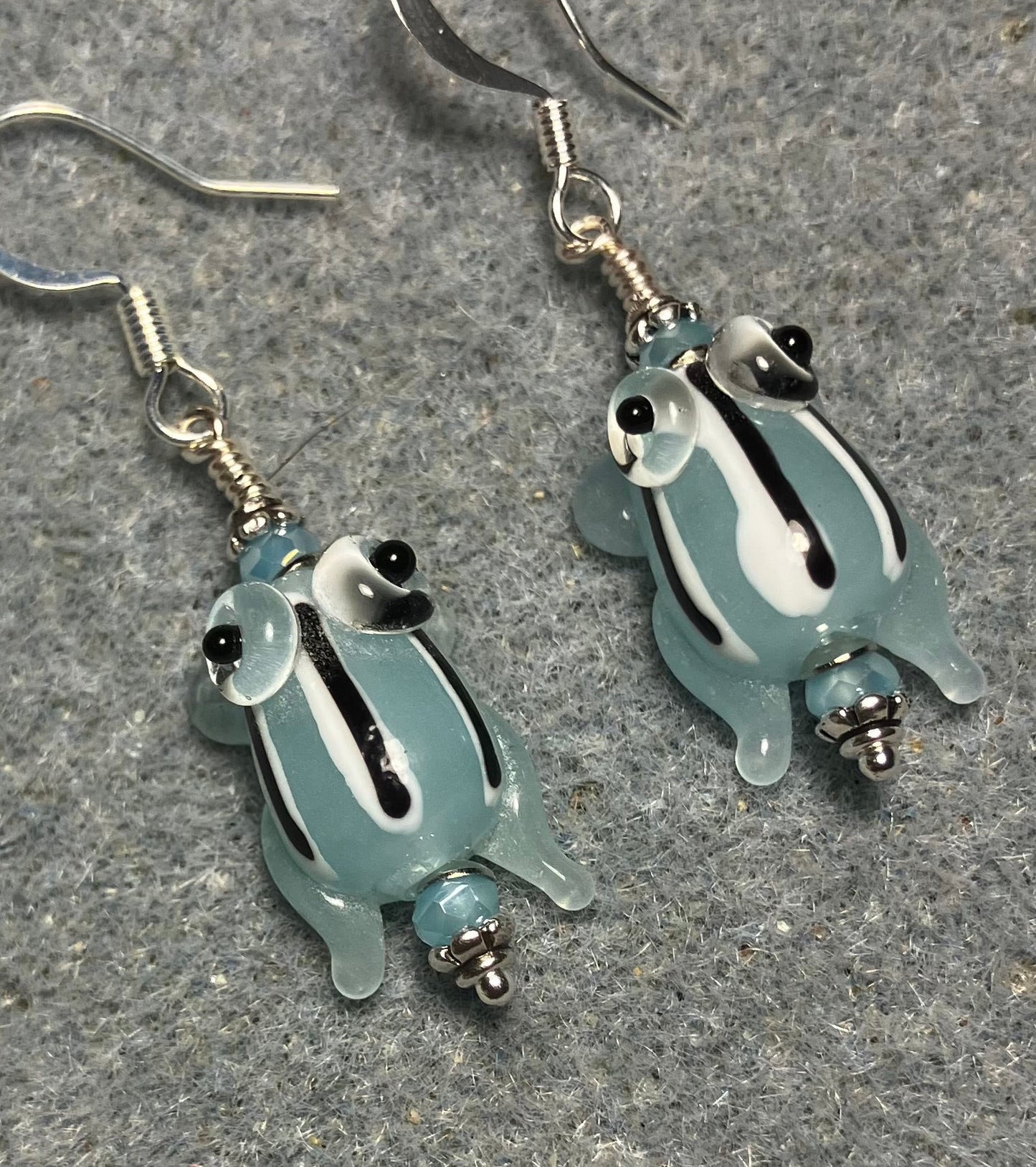 Very small translucent light blue with black stripes lamp work frog bead earrings adorned with light blue Chinese crystal beads.