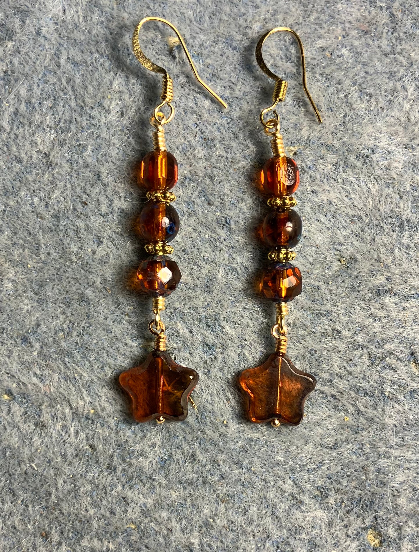 Small translucent dark amber Czech glass star bead earrings adorned with dark amber Czech glass beads.
