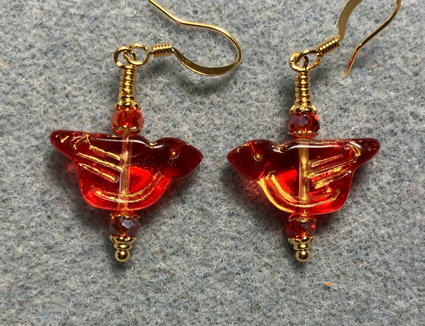 Translucent red (with gold wash) Czech glass bird bead earrings adorned with red Chinese crystal beads.