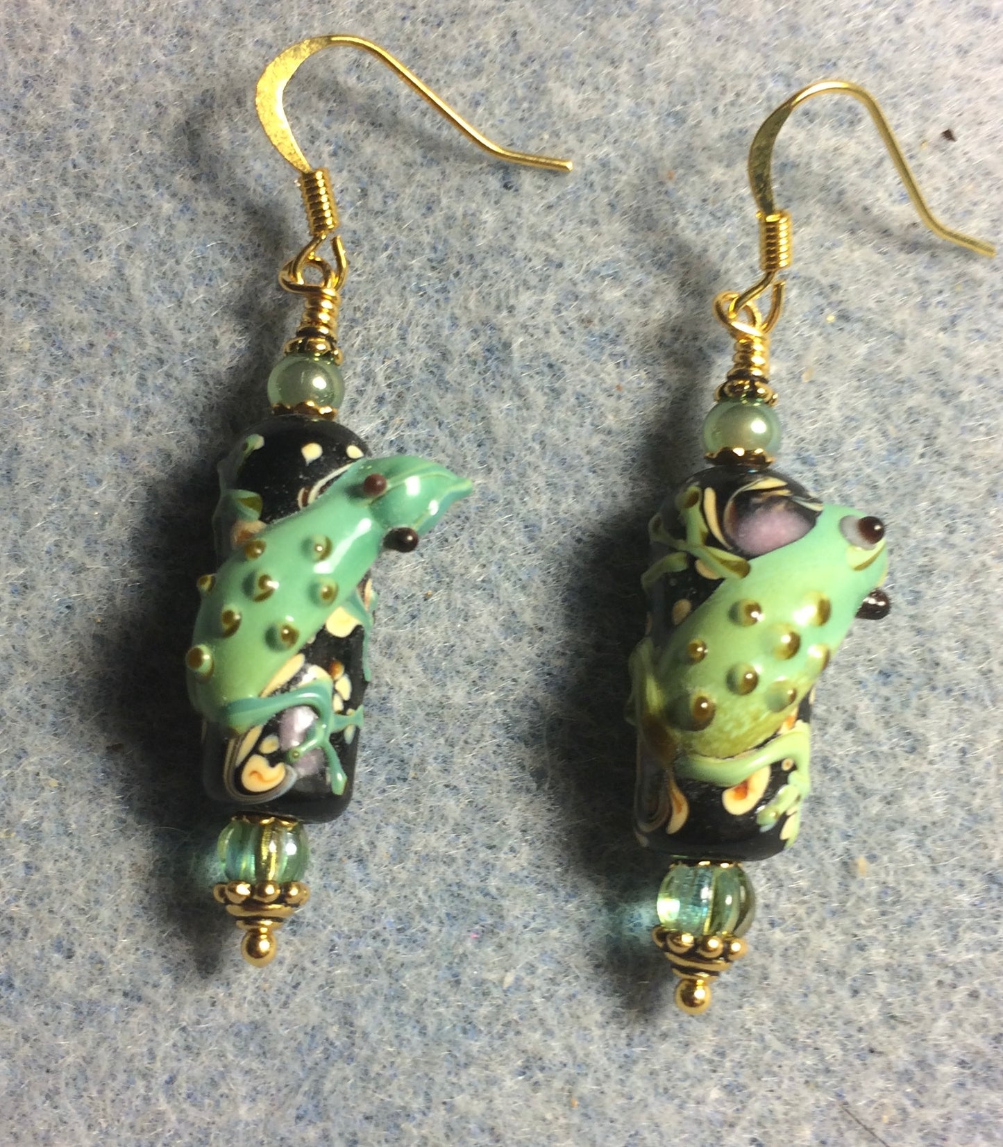 Black and green lamp work lizard bead earrings adorned with green Czech glass beads.
