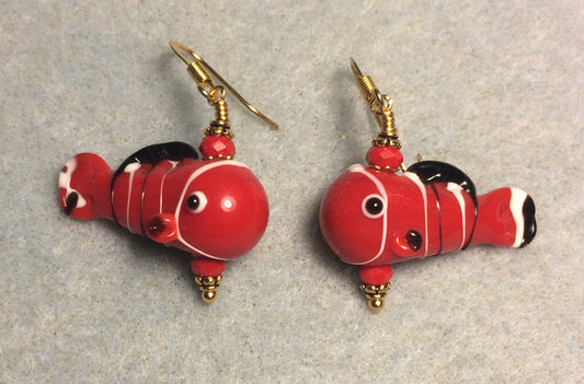 Red, black, and white lamp work fish bead earrings adorned with red Chinese crystal beads.