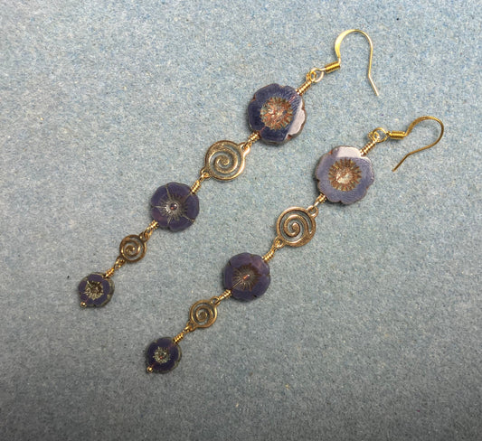 Extra long purple flower bead earrings made with three sizes of purple Czech glass pansy beads joined by gold swirly connectors.