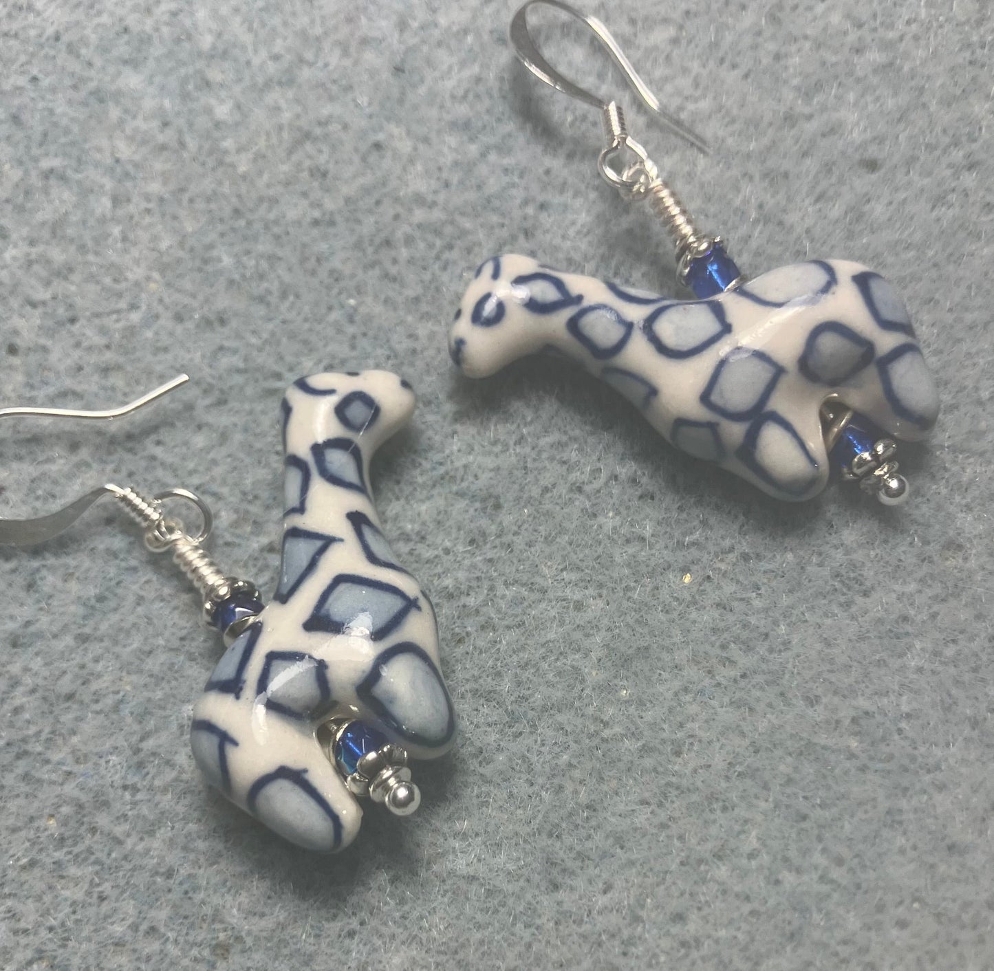 Dark blue and white ceramic spotted giraffe bead earrings adorned with small dark blue Czech glass beads.