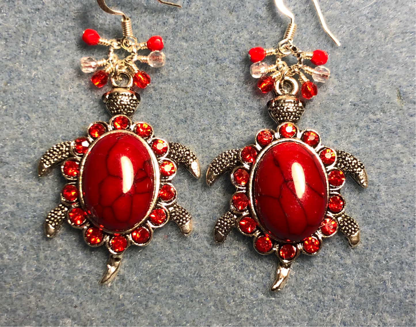 Large silver and red gemstone and rhinestone turtle charm earrings adorned with small dangling red and clear Czech glass beads.