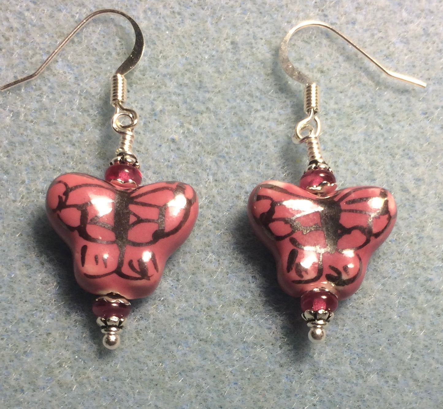 Pink and black ceramic butterfly bead earrings adorned with dark blue Chinese crystal beads.