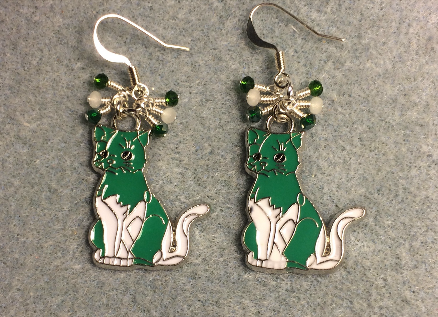 Green and white enamel cat charm earrings adorned with tiny dangling green and white Chinese crystal beads.